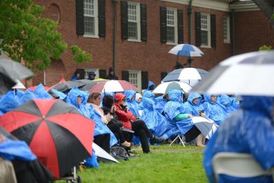 Attendees hold umbrellas
